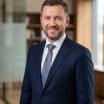 Портрет уверенного бизнесмена компании ЭнергоМех на нейтральном фоне для раздела о модернизации оборудования